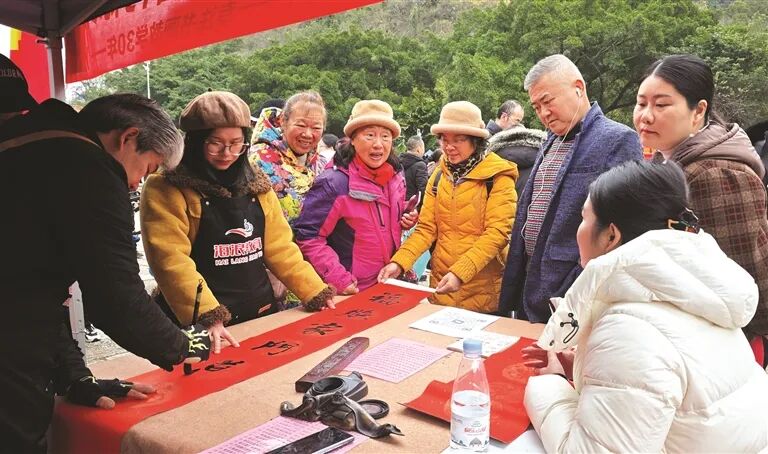 书法志愿者为市民游客书写春联。